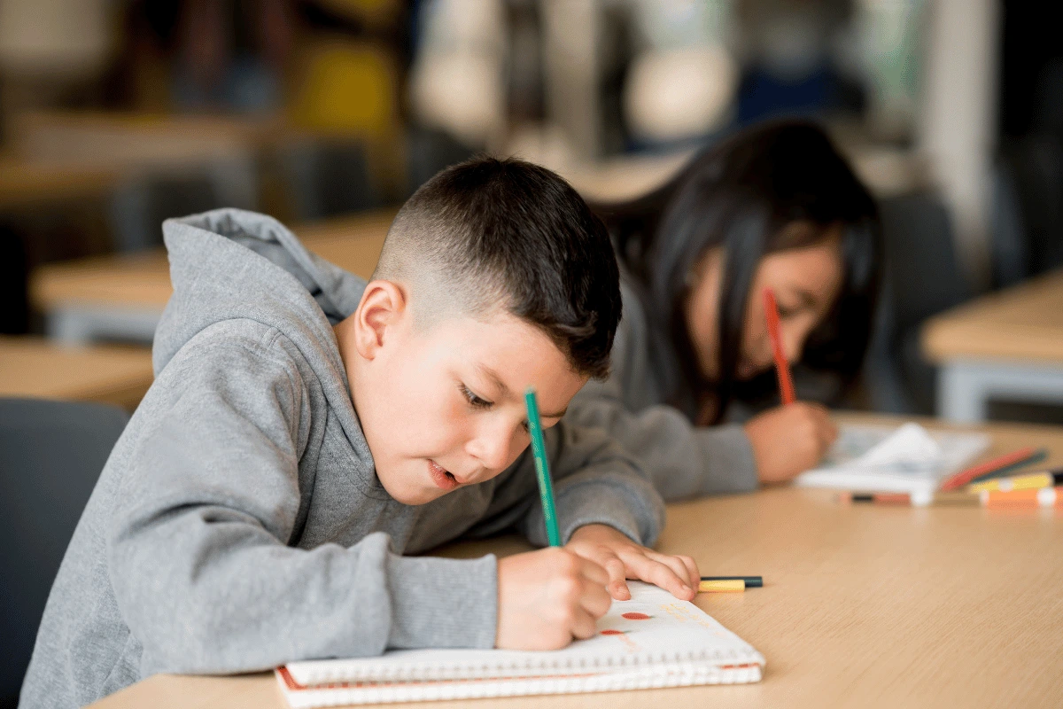 a kid sitting at his desk at school